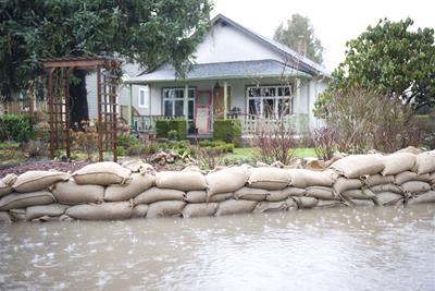 home with sandbags in front blocking flood waters