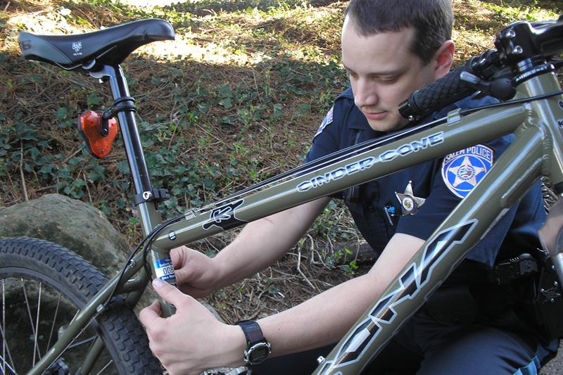 Police officer placing sticker on bike