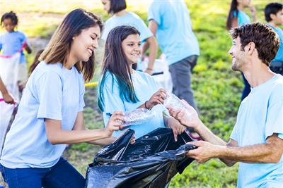 family-helps-beautify-their-community-by-picking-up-trash-in-park