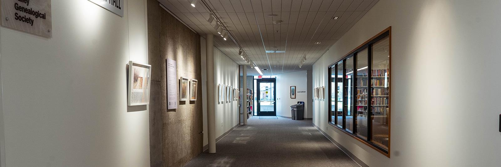 Hallway in Salem City Library with framed art on both walls.