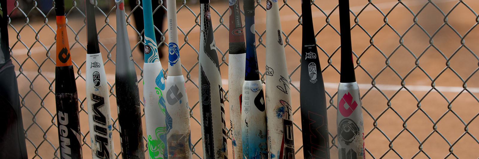MariChambers-softball-bats-against-chainlink-fence-1600x533