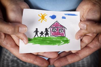 child and mom holding a drawn house with family