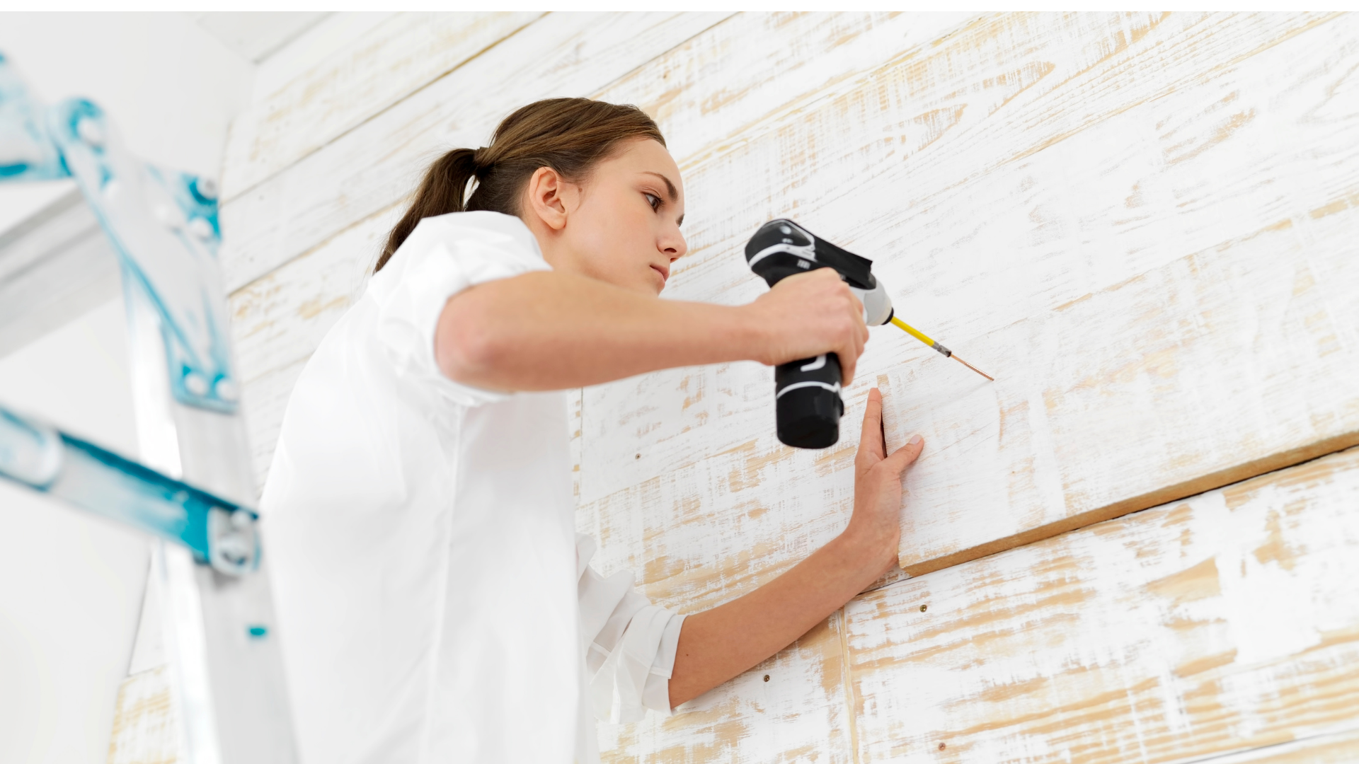 Woman drilling into wall home improvement.