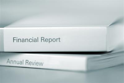 financial report and annual review booklets stacked atop each other