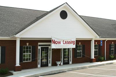 now leasing banner displayed on front of office building