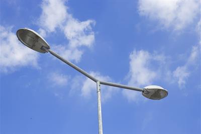 two streetlight lamps against sunny blue sky