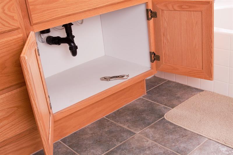open cabinet doors with pipes visible